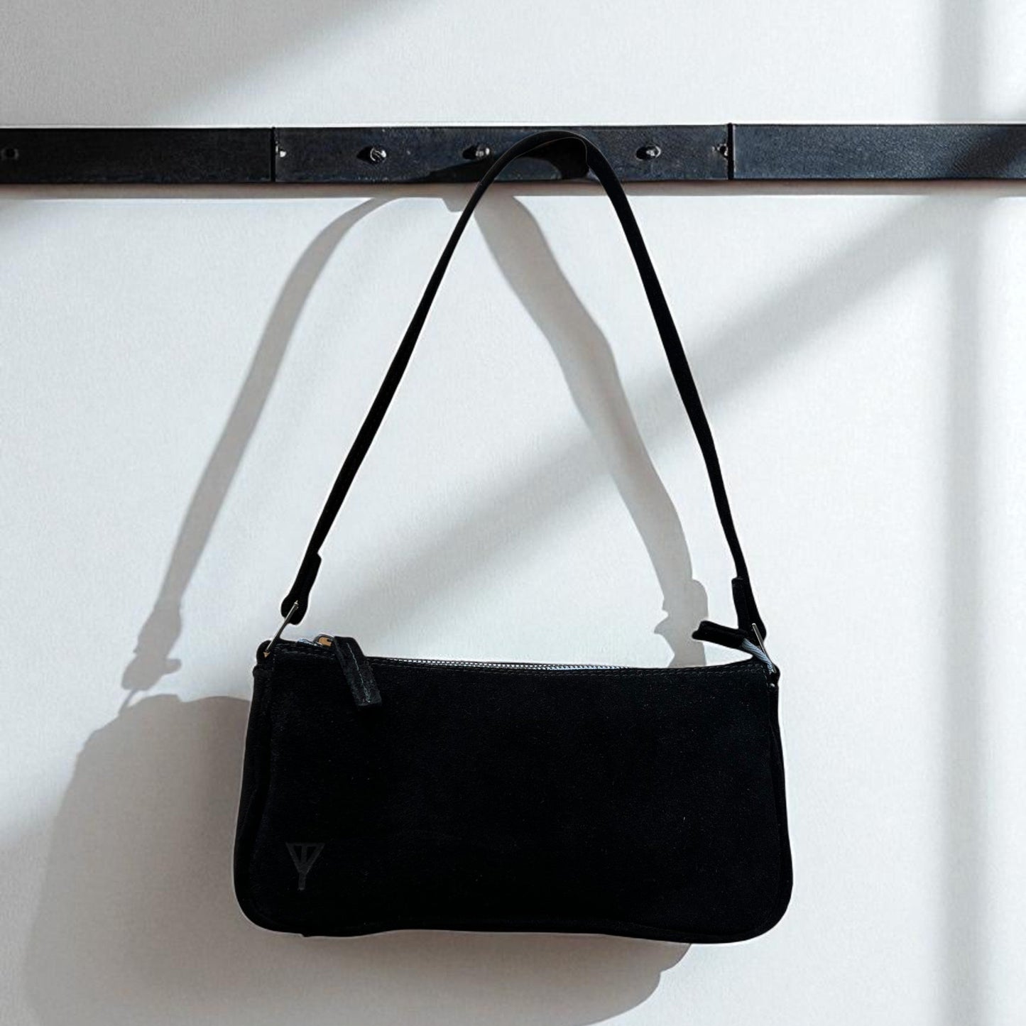 Black handbag with a strap on a white background