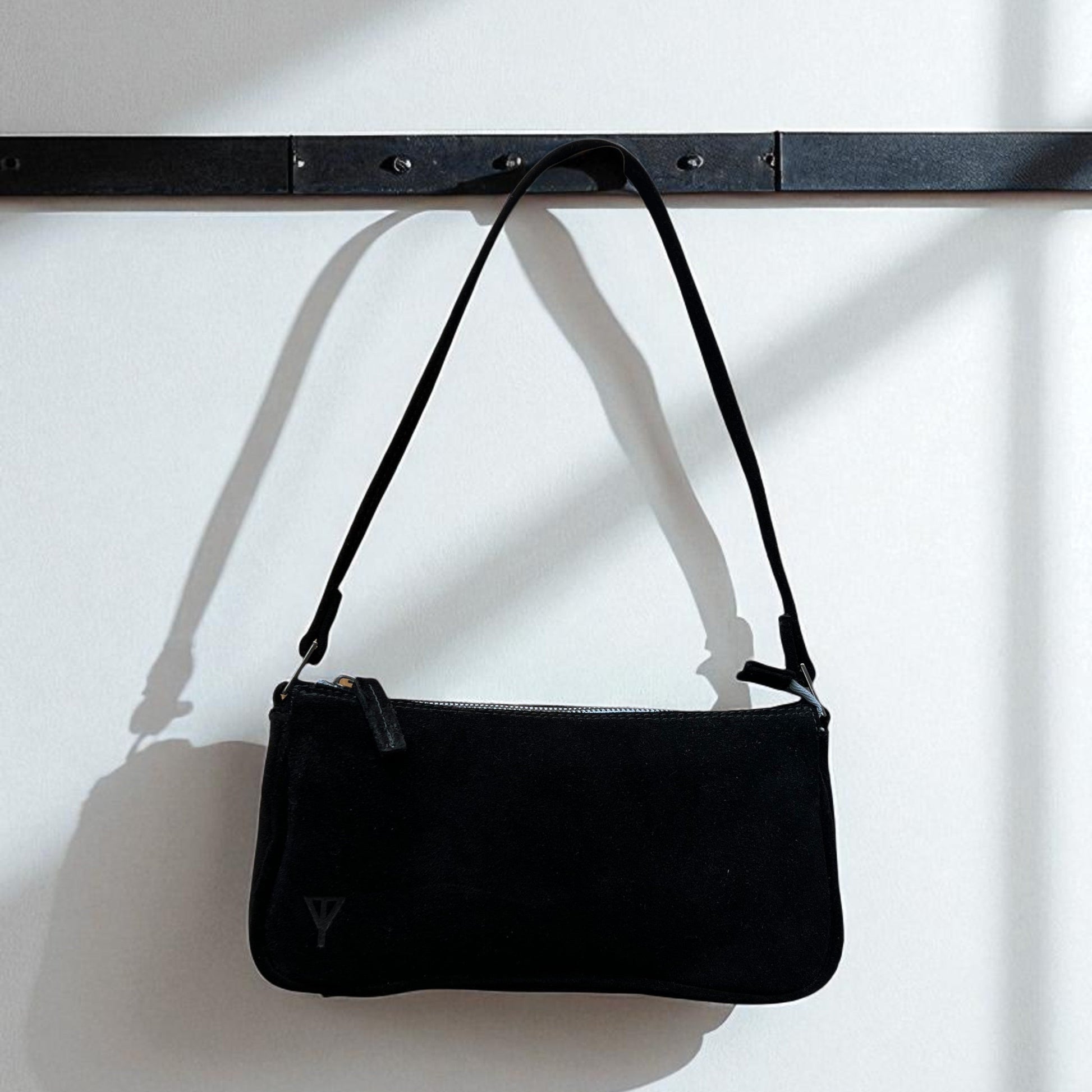 Black handbag with a strap on a white background