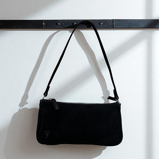 Black handbag with a strap on a white background
