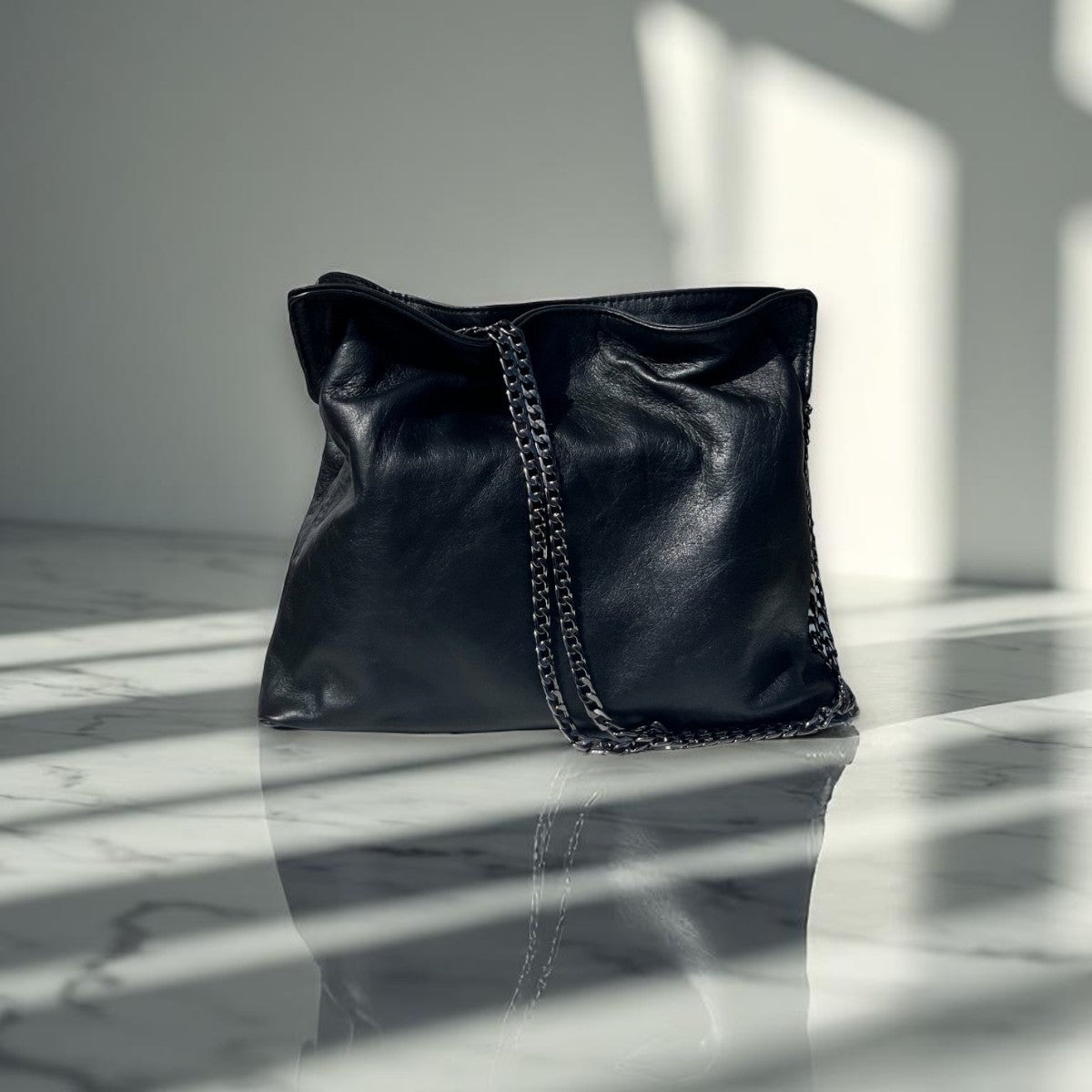 Small Soft Black leather bag named Tilly with chain detail strap by Taylor Yates - Front View on a marble surface