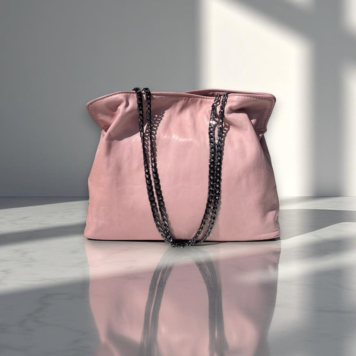 Soft leather clutch bag in Soft Pink Leather  with Chain Strap by Taylor Yates – front view on a white marble surface