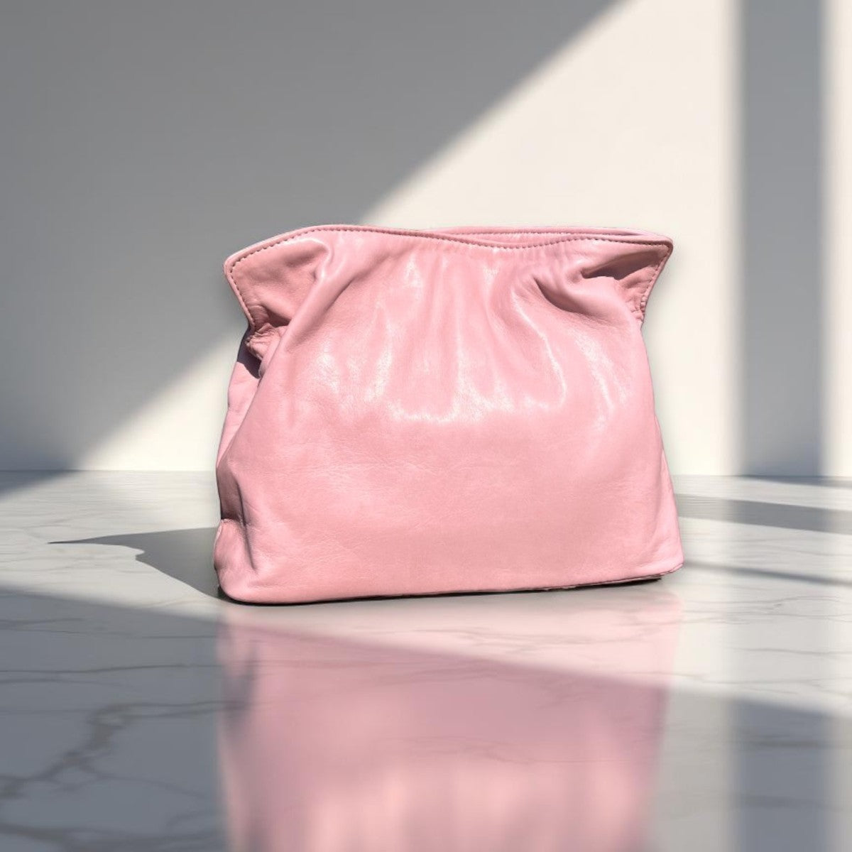Soft leather clutch bag in Soft Pink Leather by Taylor Yates – front view on a white marble surface